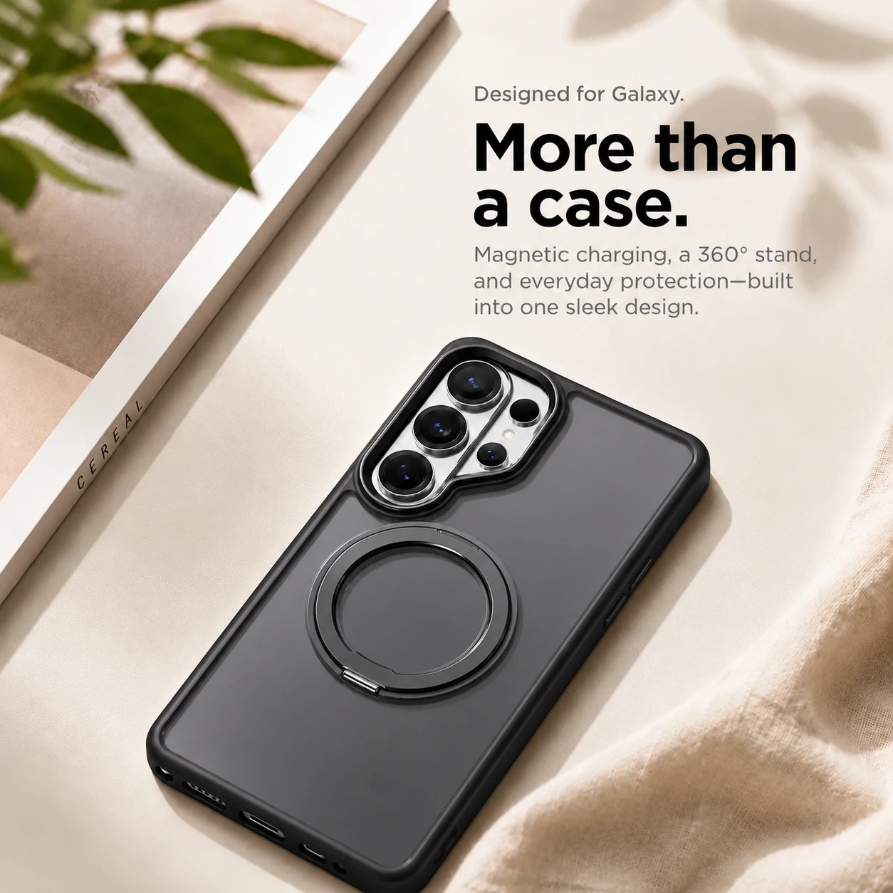 Black ring stand phone case resting on a pale fabric surface beside a book #color_Midnight Black