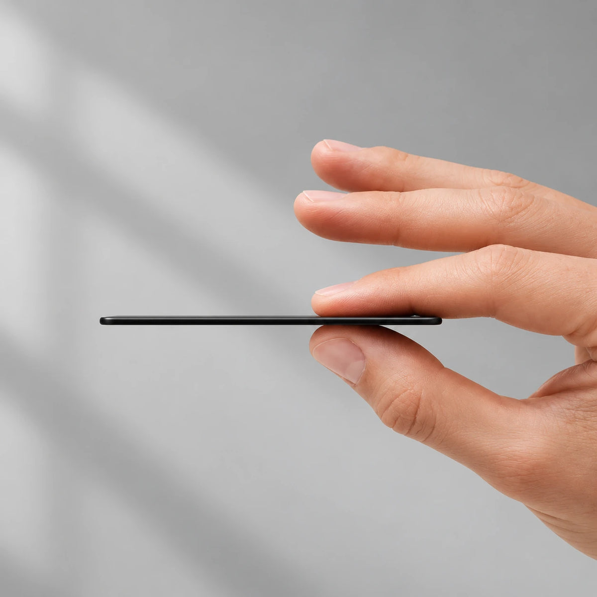 Thin edge of a black tracker card held between two fingers.