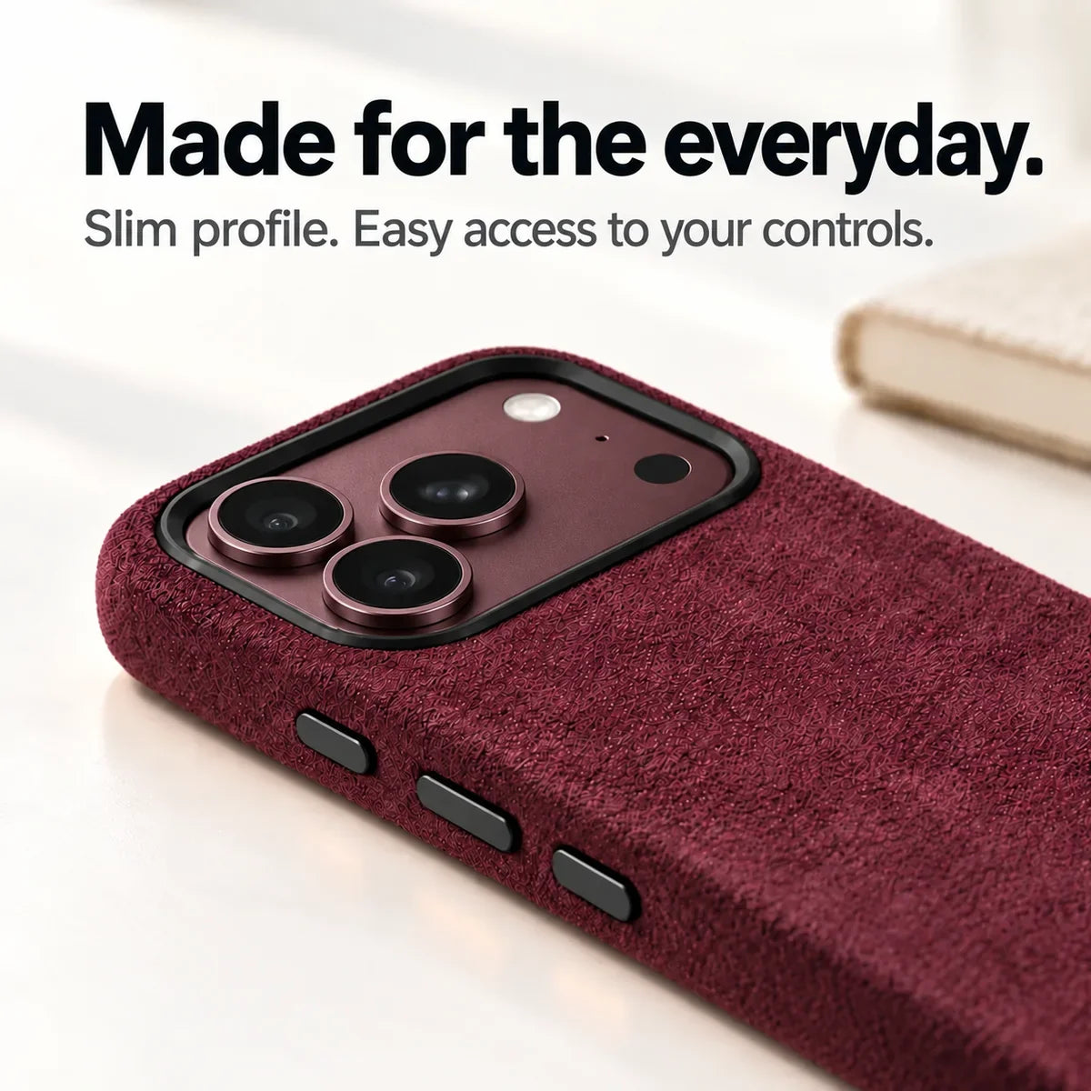 Low-angle view of a Burgundy fabric phone case with a matching Burgundy phone camera surface and black rim. #color_Burgundy