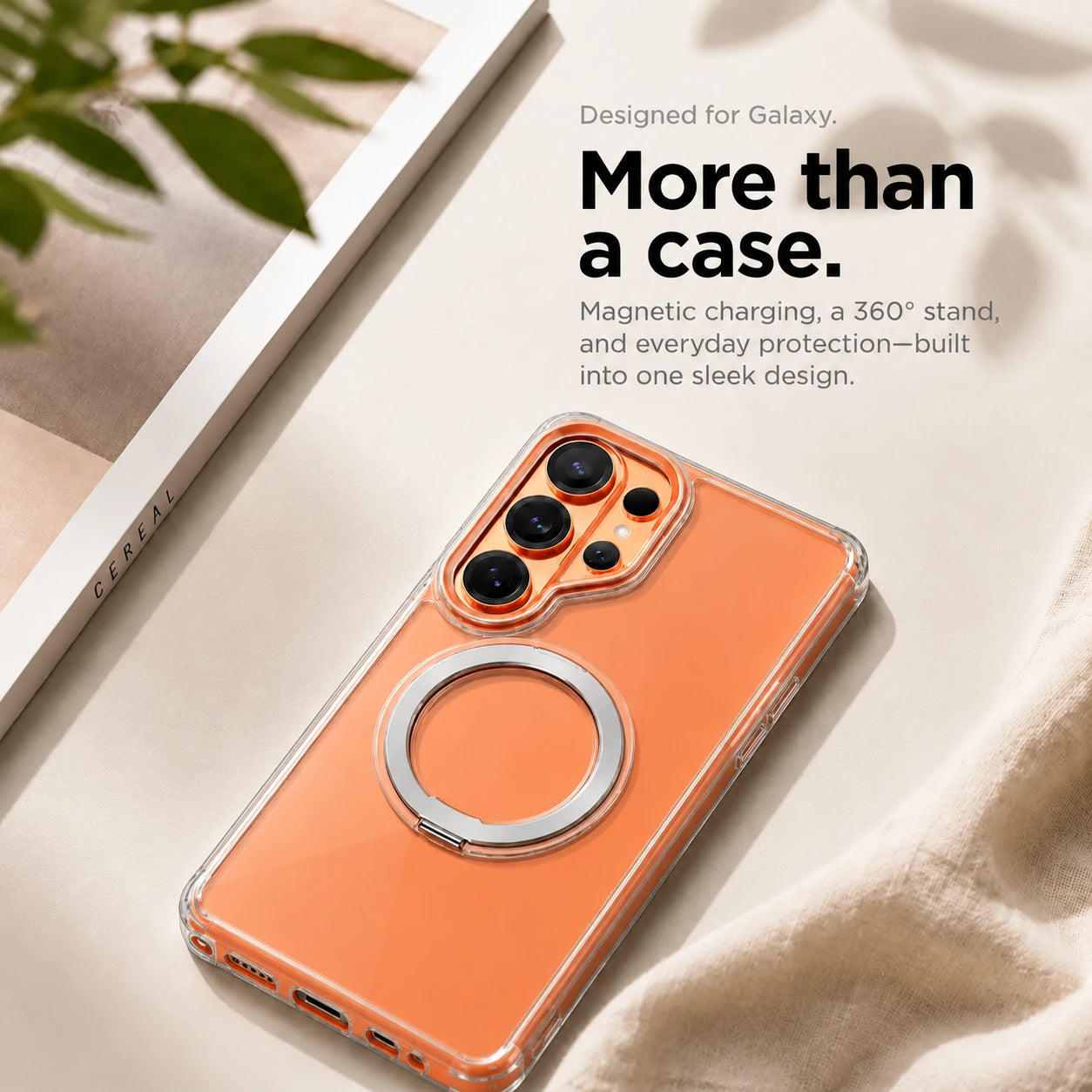 Clear ring stand phone case resting on a pale fabric surface beside a book #color_Transparent