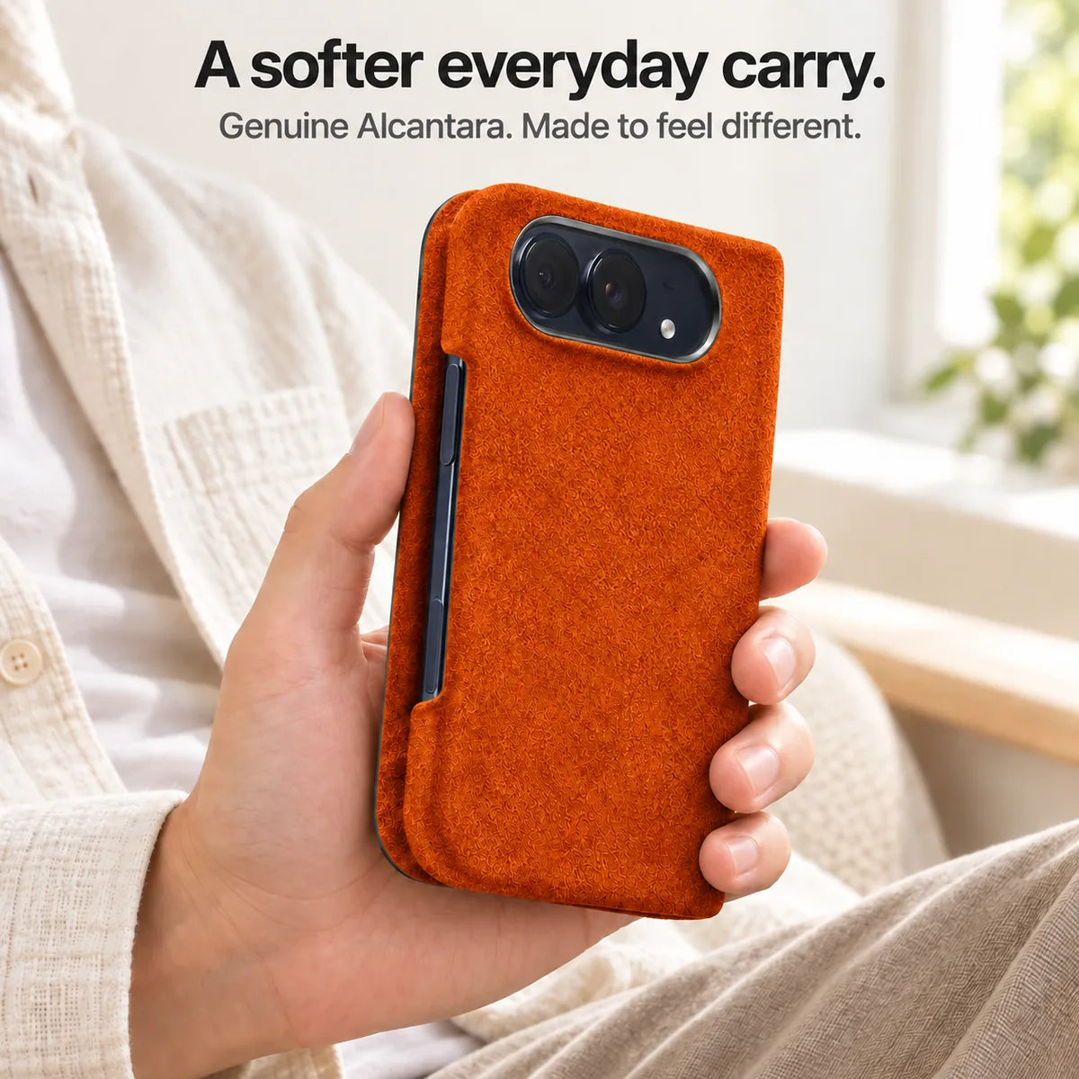 Cosmic Orange Alcantara folio case for iPhone Duo, held in a hand to show the soft fabric finish #color_Cosmic Orange