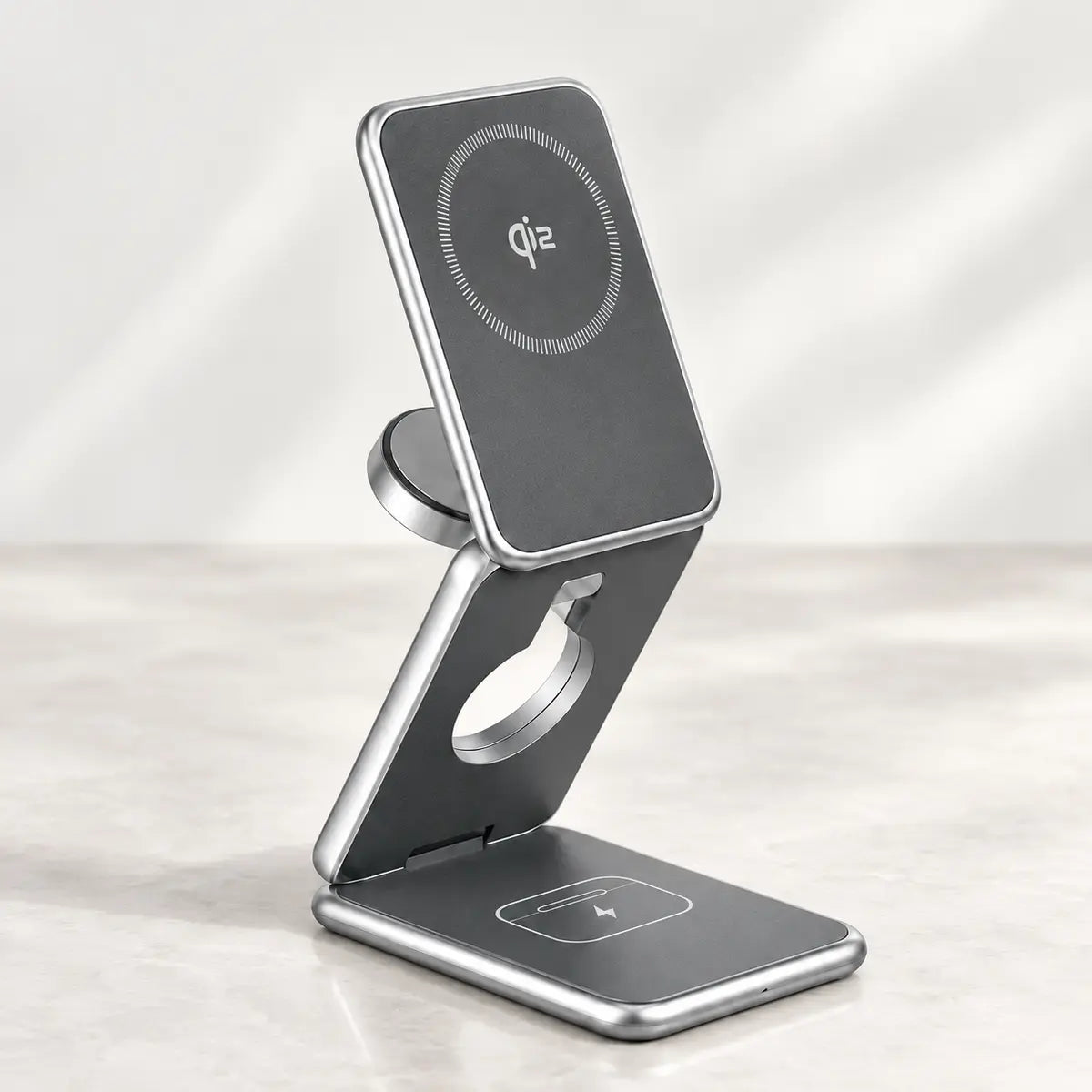 Silver folding wireless charger with a rectangular phone pad, separate round watch connector and earbud charging base