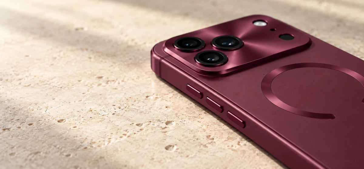 Close view of a burgundy alloy phone case showing the camera surround and three side buttons.