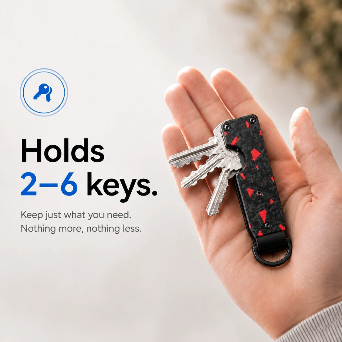 Carbon Red compact tracking key organizer holding several keys in a palm #color_Carbon Red