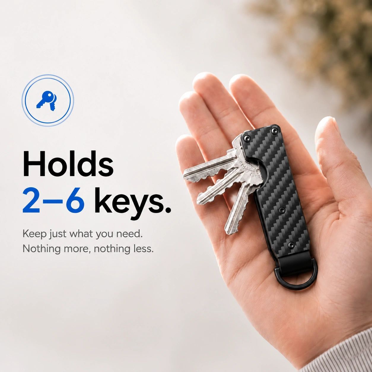 Carbon Weave compact tracking key organizer holding several keys in a palm #color_Carbon Weave