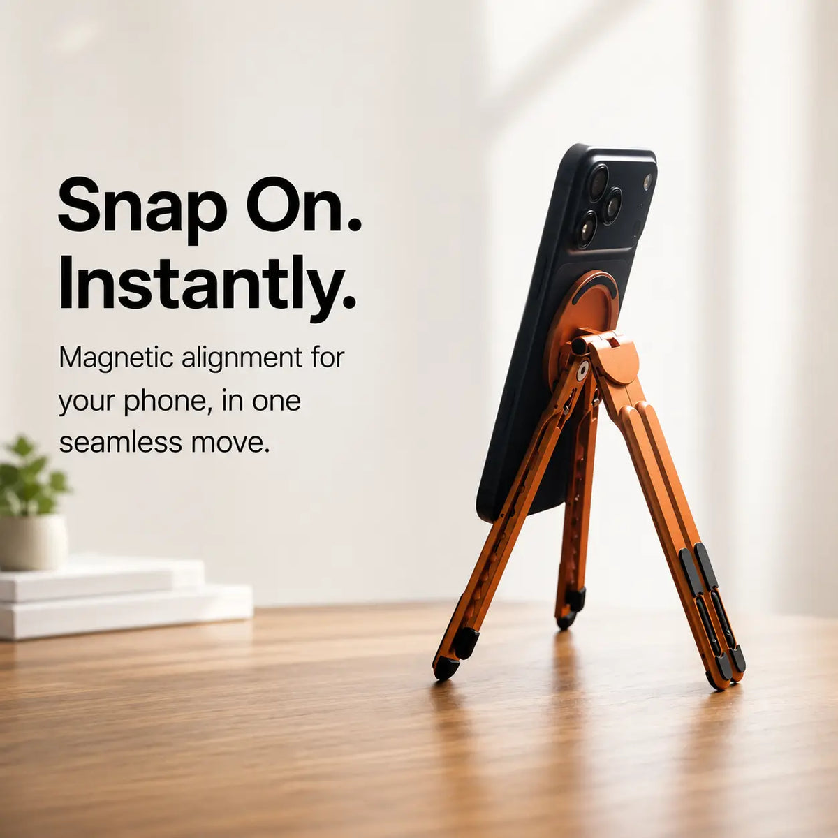Cosmic Orange magnetic tripod stand supporting a Burgundy iPhone from behind. #color_Cosmic Orange