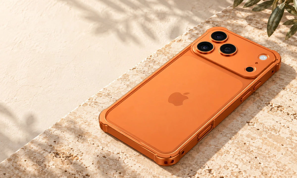 Slim orange aluminum phone bumper viewed from the side on a stone desk.