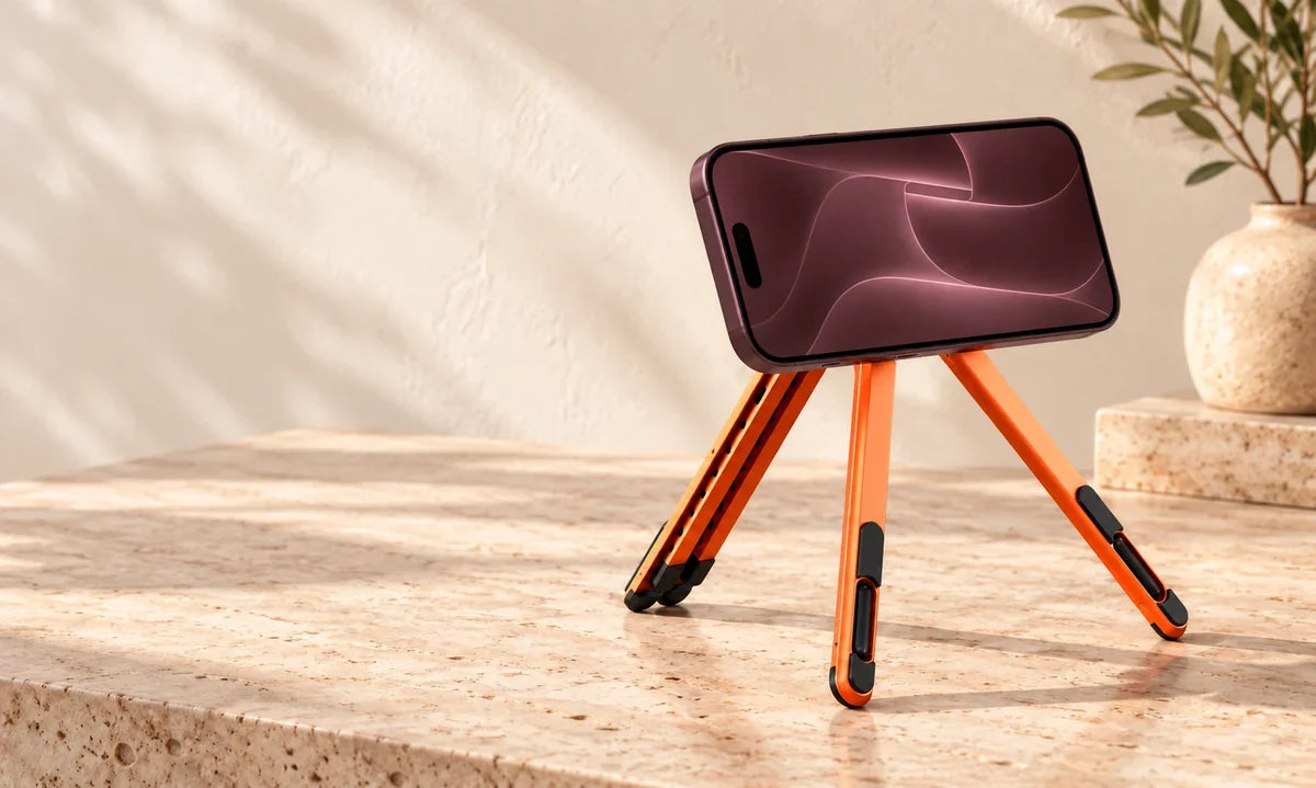 Orange magnetic desk stand holding a phone horizontally for viewing.