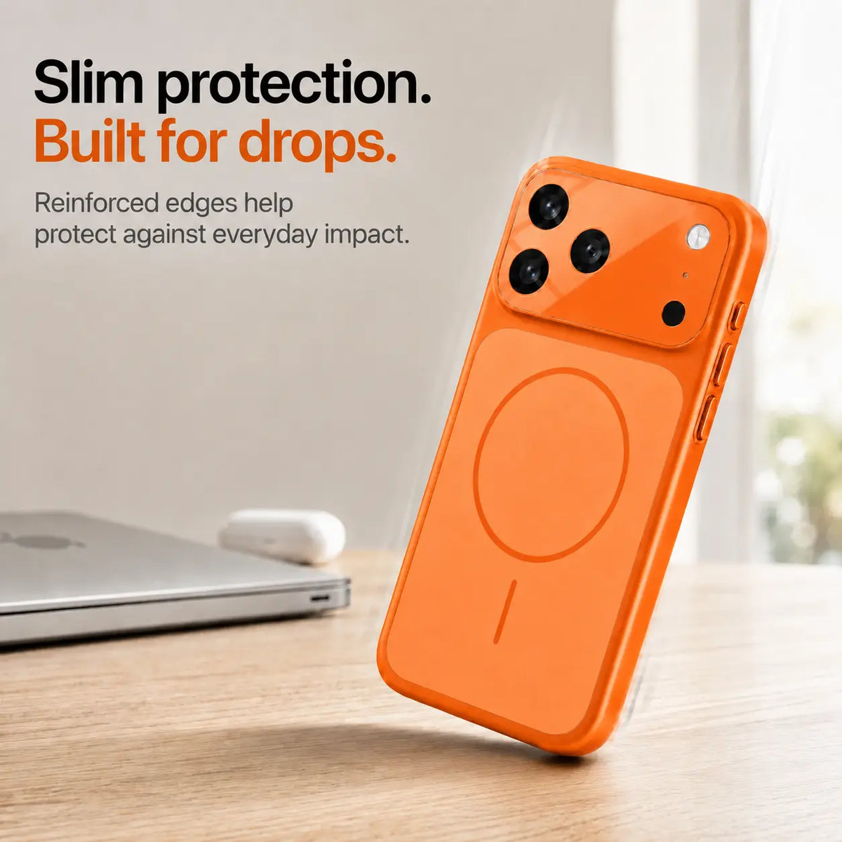 Orange slim phone case leaning on one corner on a wooden desk, showing reinforced edges #color_Cosmic Orange