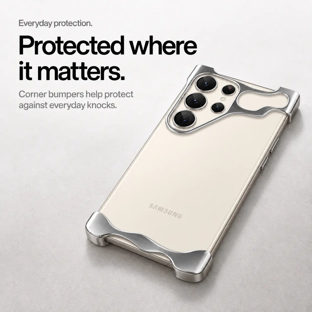Silver open-edge phone case lying on a desk to show its raised corners #color_Silver