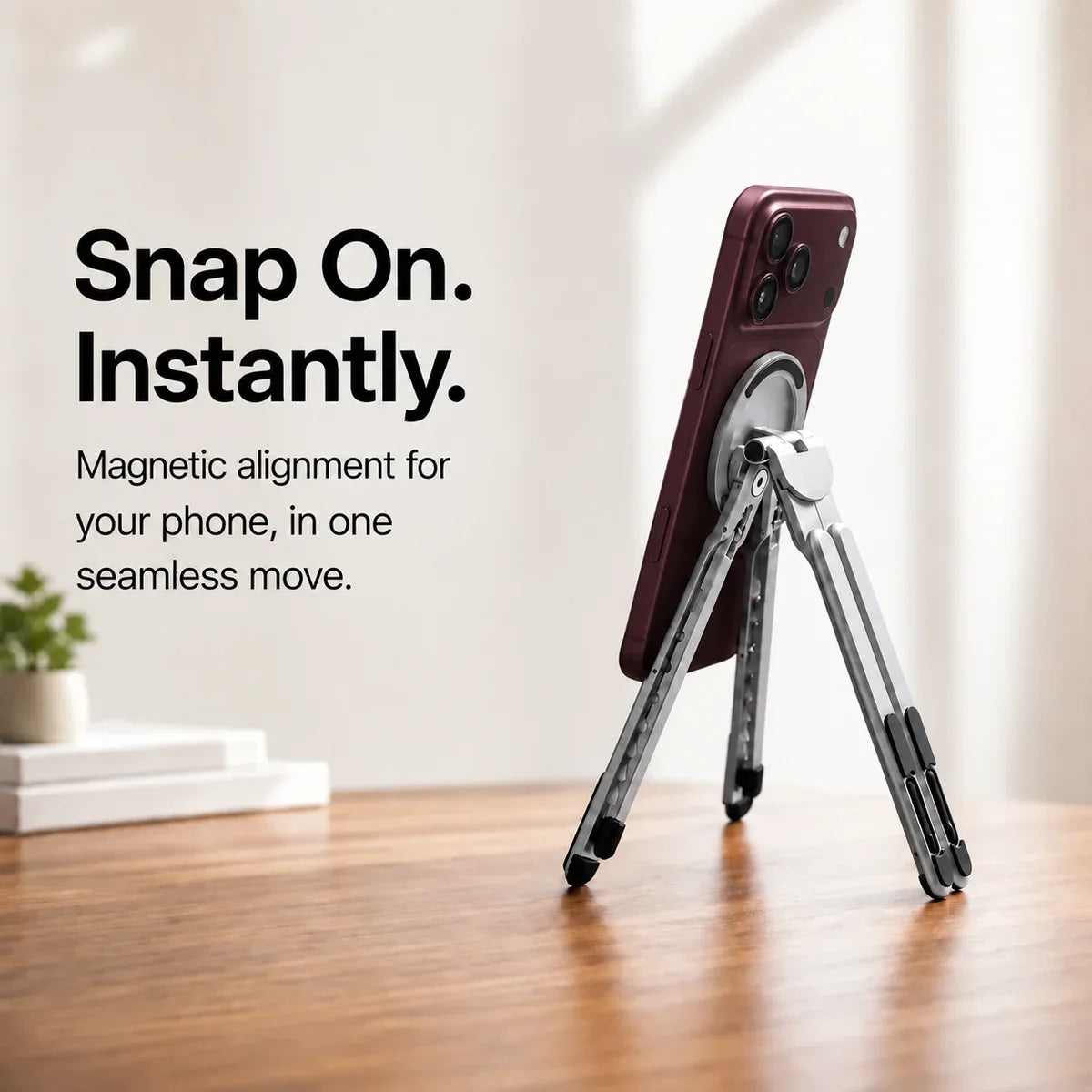 Titanium Silver magnetic tripod stand supporting a Burgundy iPhone from behind. #color_Titanium Silver